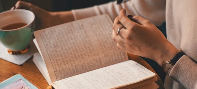 Woman drinking a cup of tea and journaling.
