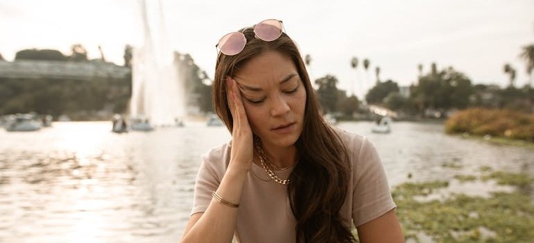 Woman holding her temple in pain.