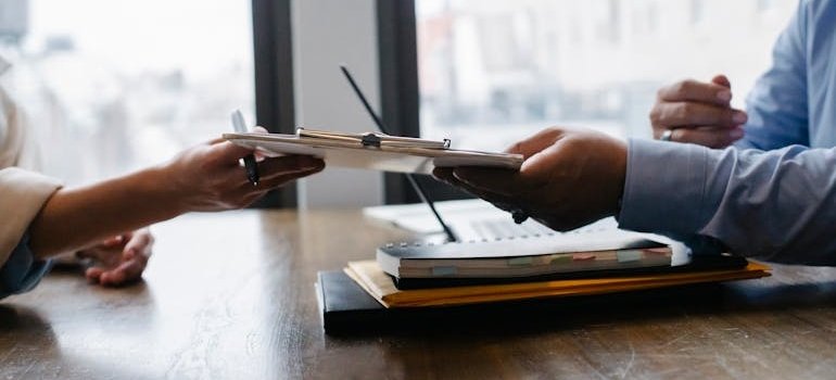 HR handing a document to an employee regarding how to go to rehab without losing your job.