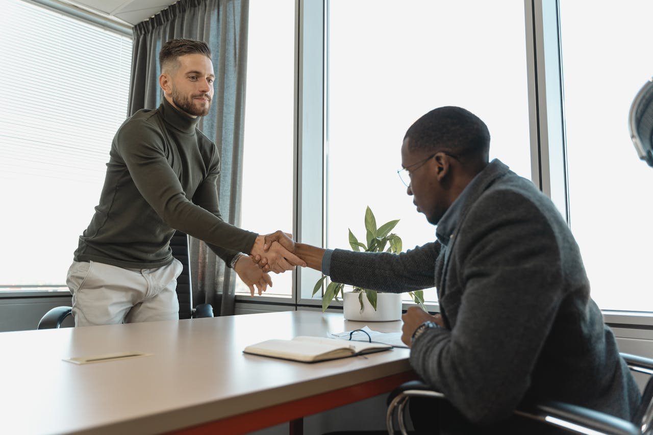 Two men shaking hands in an office.