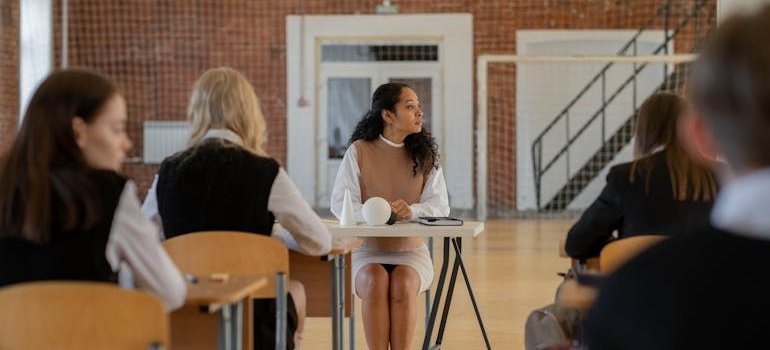 Woman holding a lecture about socioeconomic status and addiction in a school.