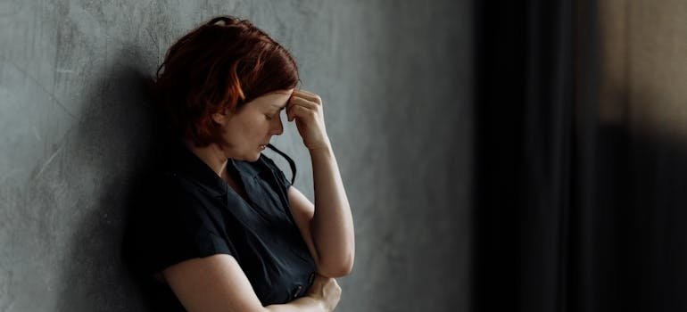 Woman leaning against a wall.