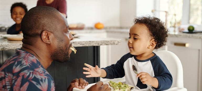 Man eating breakfast with his child.