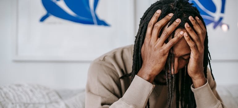 Man holding his head and worrying about life after inpatient rehab.