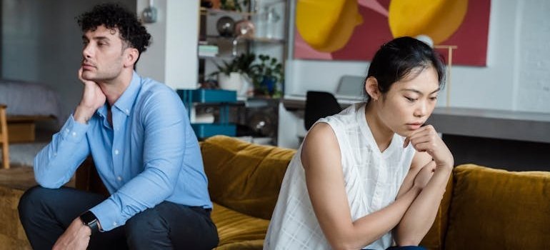 Woman and man sitting on a couch and not speaking to each other.