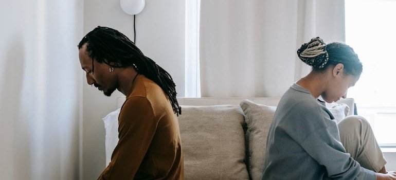 Couple sitting on the bed after fighting about addiction and divorce.