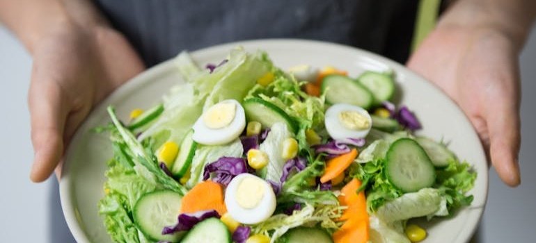 Person holding a plate with a healthy meal on it.