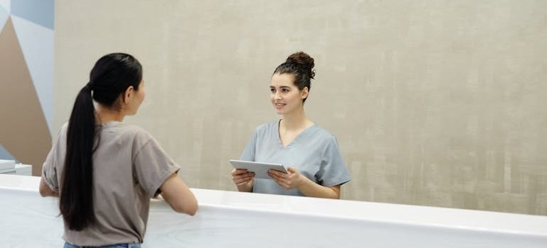 Woman talking to a receptionist.