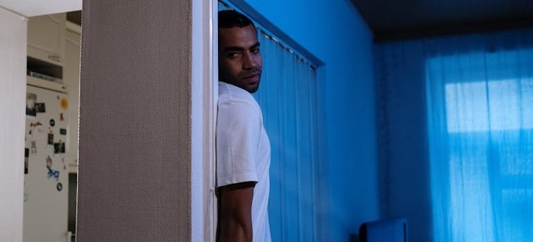 Man hiding behind a door.