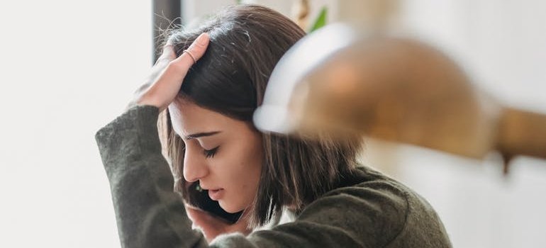 Distressed woman calling an ambulance for help for alcohol poisoning.