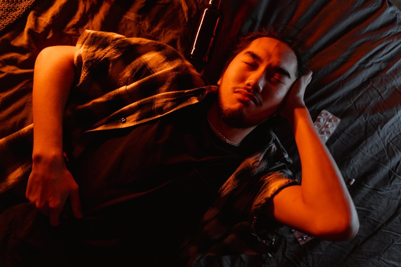 Man sleeping on the bed after ingesting Klonopin and alcohol.