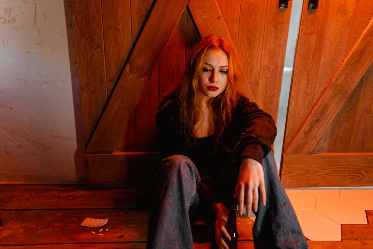 Poly addict sitting on the floor and drinking beer.