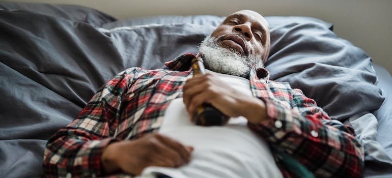 Man sleeping and holding a beer bottle after ingesting Klonopin and alcohol.