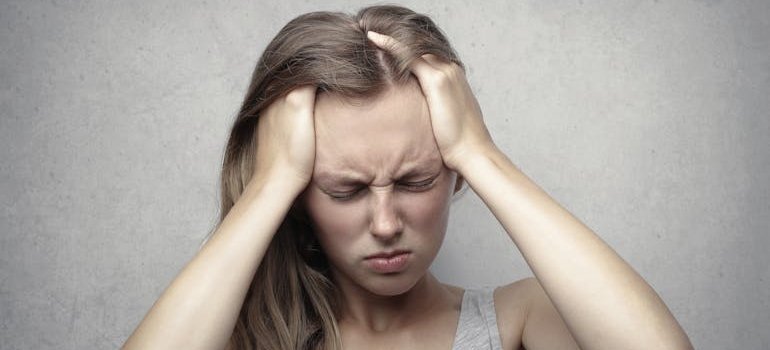 Stressed woman holding her head in pain.