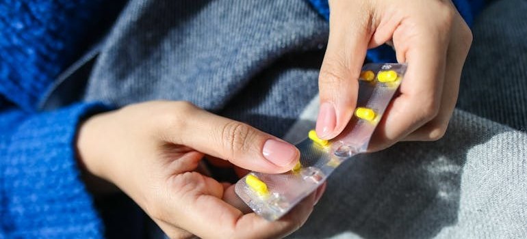 Woman taking out a pill from a blister.