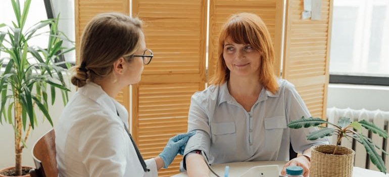 Doctor measuring her patient's blood pressure to decide between buprenorphine vs Suboxone for her.