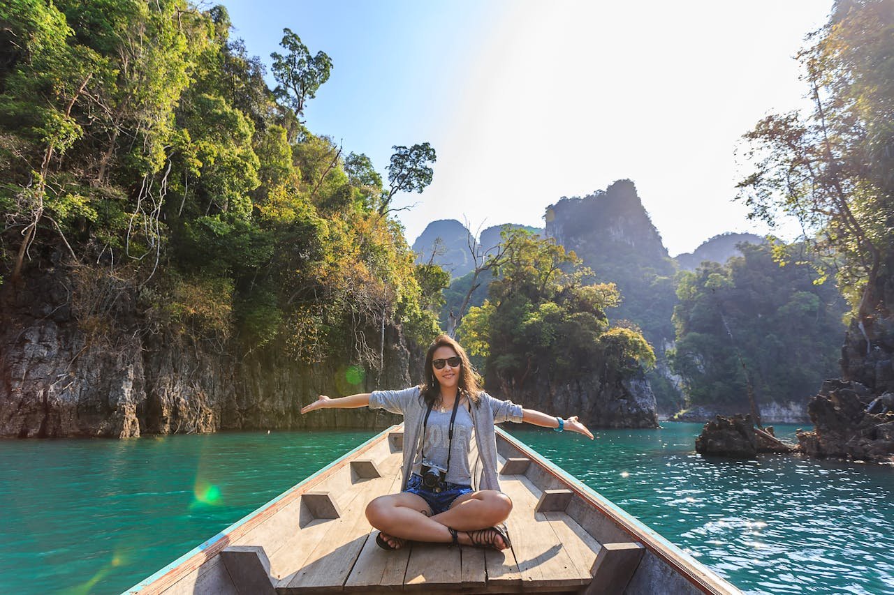 Woman sitting in a boat and enjoying sober vacations.