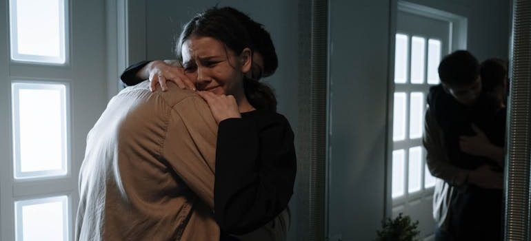 Siblings hugging and crying.