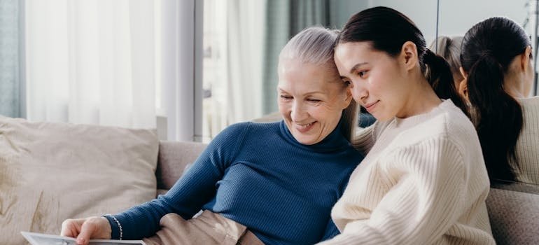 Mother and daughter smiling and going through a photo album.