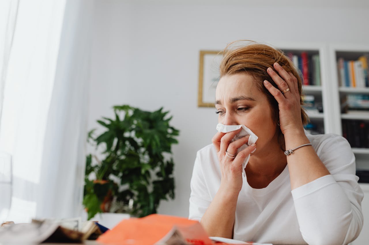 Woman wiping her nose after getting a nosebleed from cocaine.