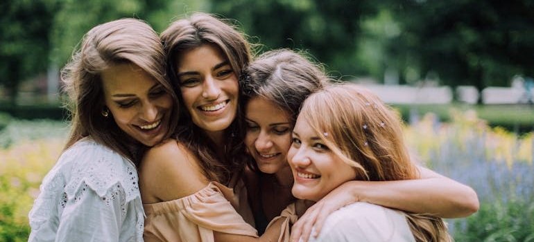 Four women smiling and hugging.