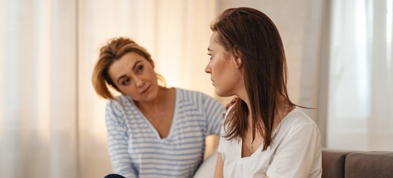 Two women discussing how to get a family member into drug rehab.