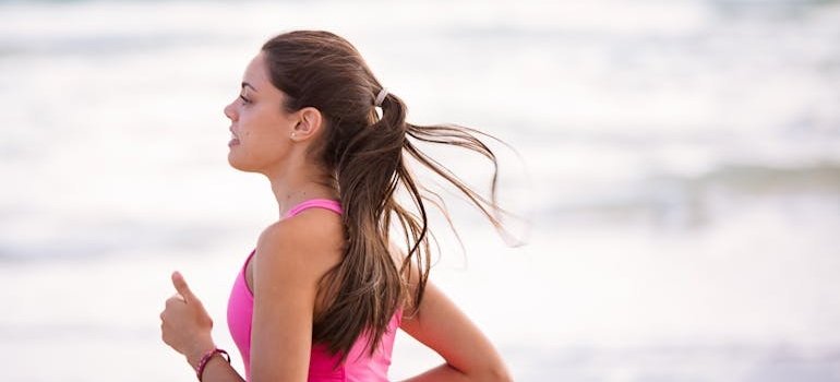 Woman jogging along the beach side.