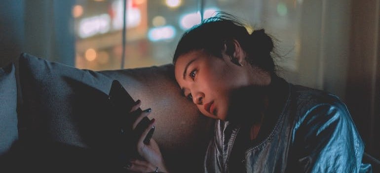 Woman sitting on the couch and looking at her phone.