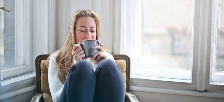 Woman drinking coffee and practicing self care tips for women.