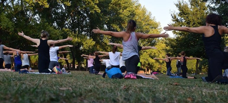 Group of women practicing yoga and gratitude exercises outdoors.
