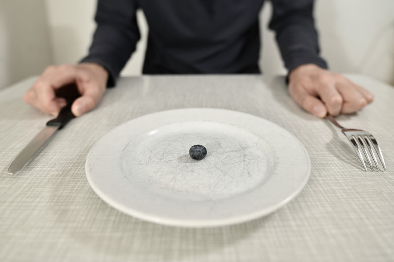 One single blueberry on a plate.