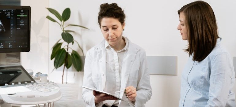 Doctor talking about when to stop smoking weed while pregnant with a pregnant patient.