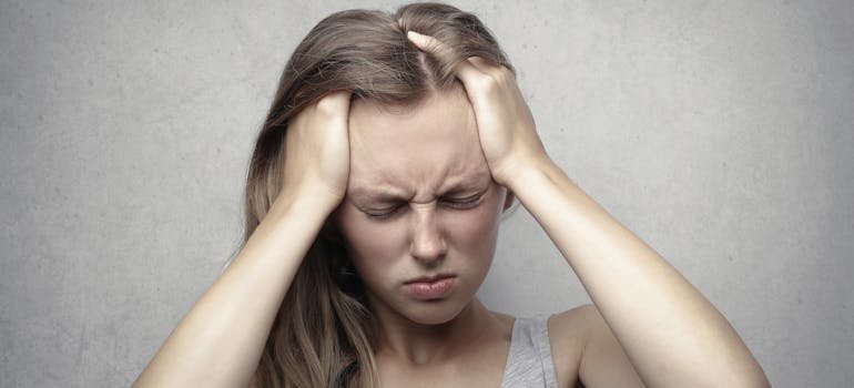 Woman holding her head while having a headache.
