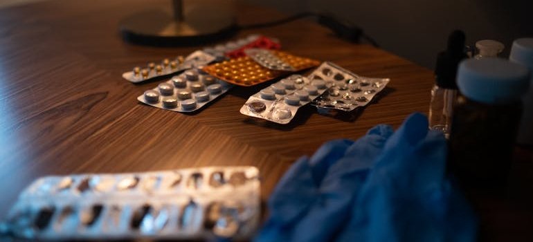 Many different blisters of pills on a bedside table.