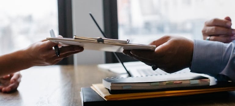 Woman handing a clipboard to an employee.