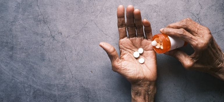 Woman putting pills in her hand.