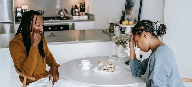Couple sitting at the table after having an argument over toxic behavior.