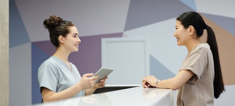 Woman talking with a nurse at a rehab center.