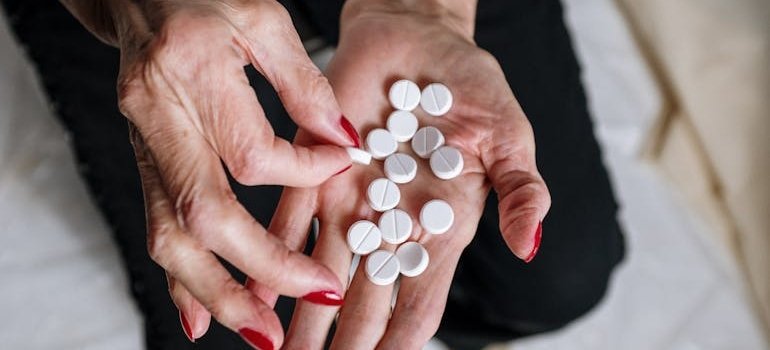 Woman counting a lot of white pills on her hand.