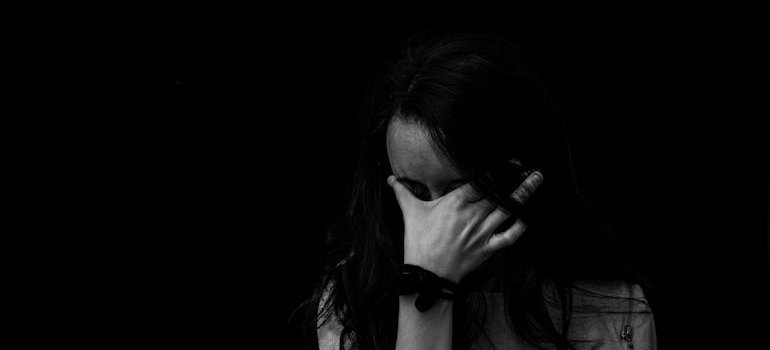 Black and white picture of a woman hiding her face.