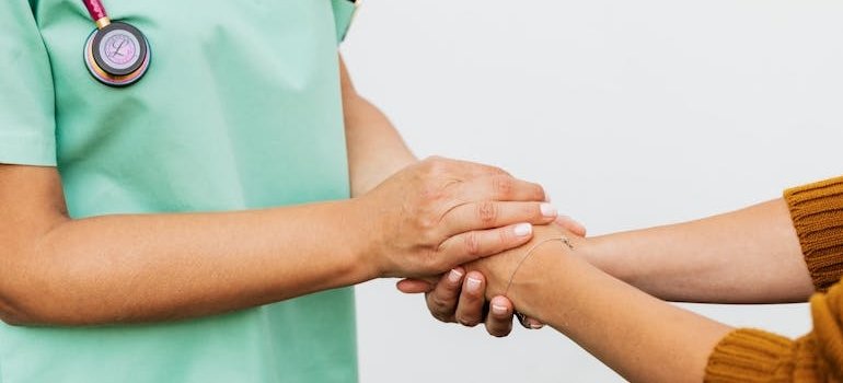 Nurse holding a woman's hand.