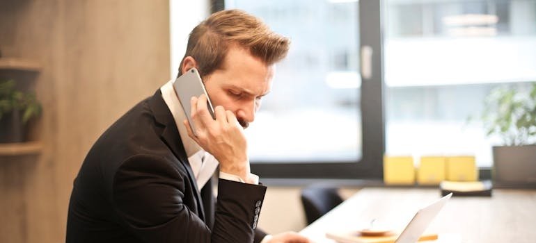 Man sitting at a desk in an office and making a phone call.