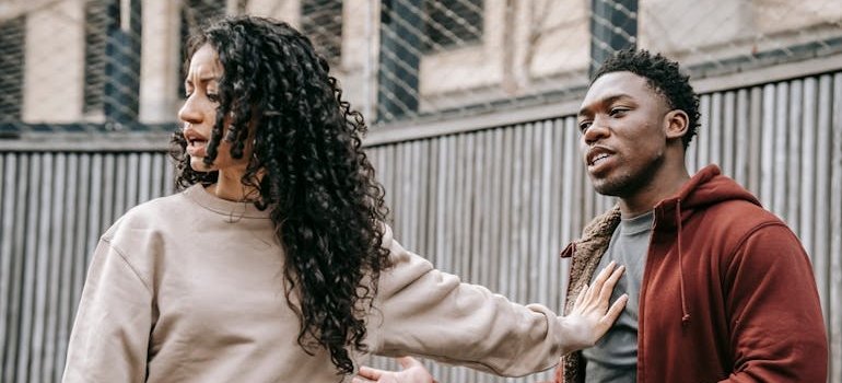 Woman having an argument with her boyfriend and pushing him away.