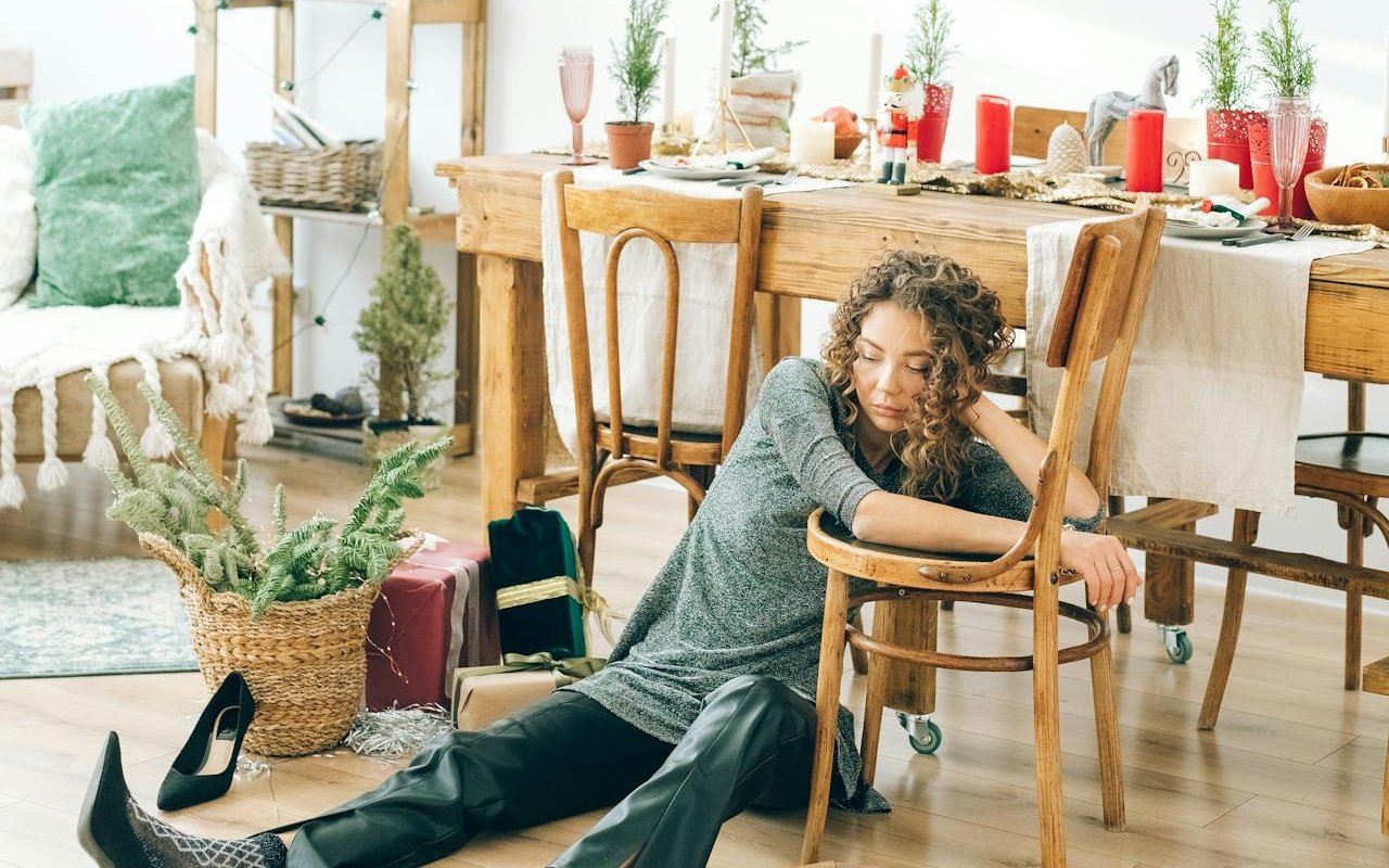 Woman sitting on the floor while suffering with Christmas depression.