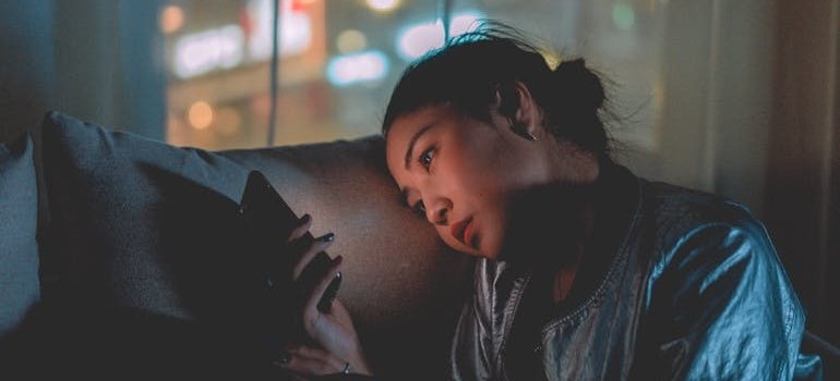 Woman sitting on the couch and looking at her phone.