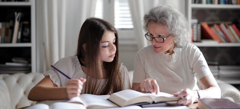 Older women studying with her granddaughter after learning how to protect a grandchild from a drug addicted parent.