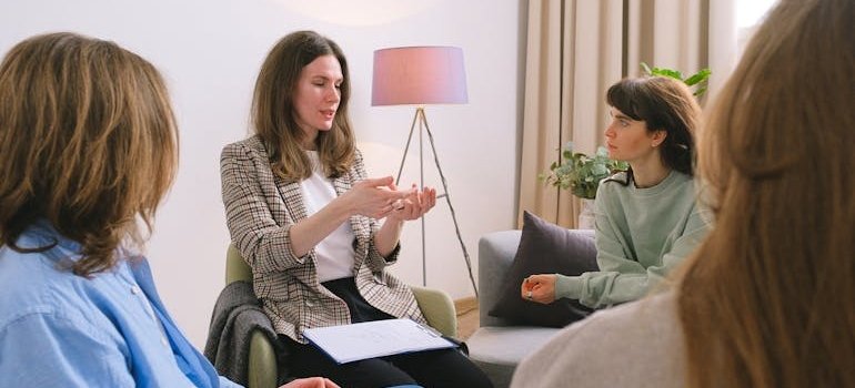Therapist talking to a group of people in mental health support groups.