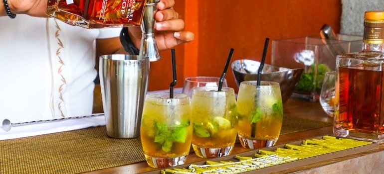 Three cocktails lined up on a bar.