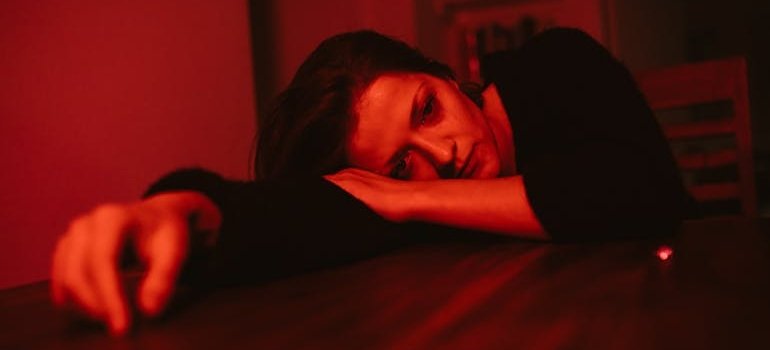 Depressed woman lying on the kitchen table.