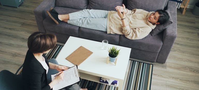 Therapist writing in a clipboard while trying to diagnose a patient with one of the common mental health disorders.